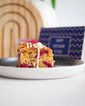 Gluten free raspberry almond cake squares topped with flaked almonds and dairy free white chocolate, handmade in the UK
